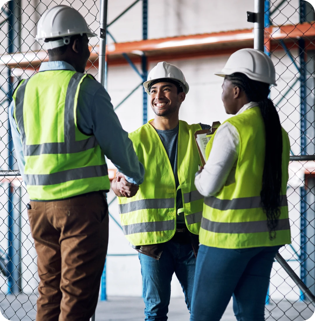 Construction workers shaking hands in warehouse