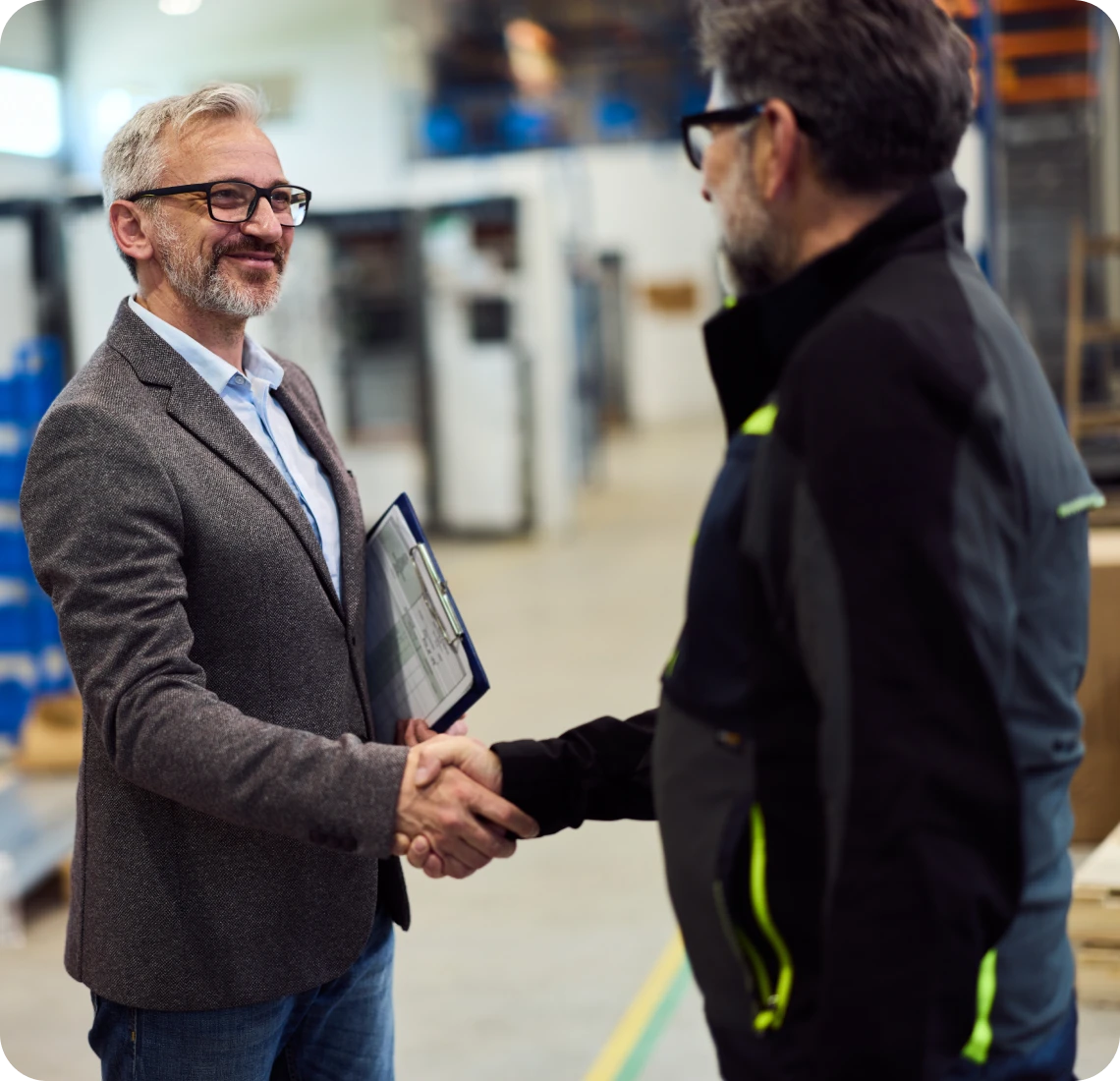 Professional handshake in a factory environment