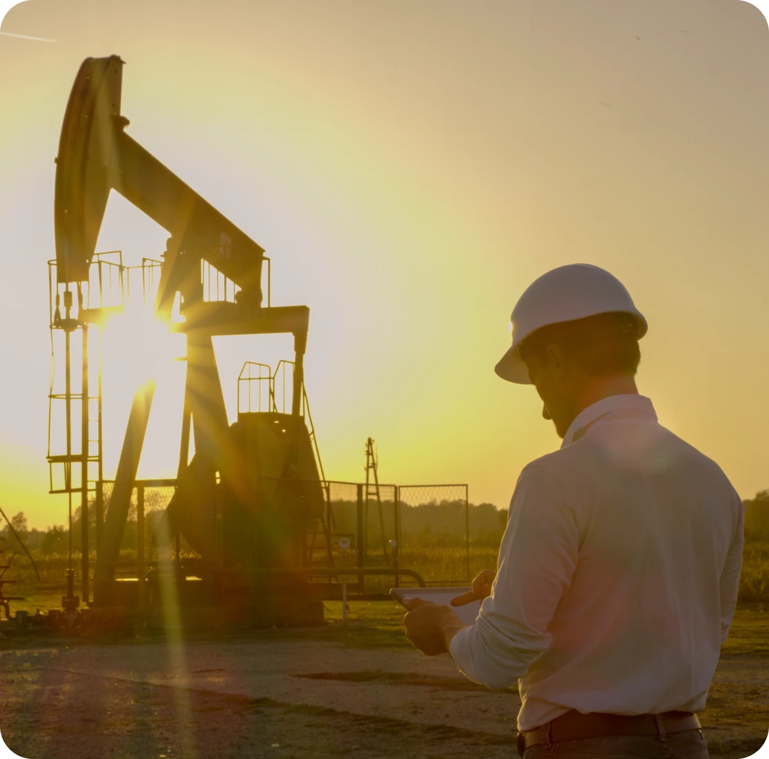 Engineer surveying oil field machinery